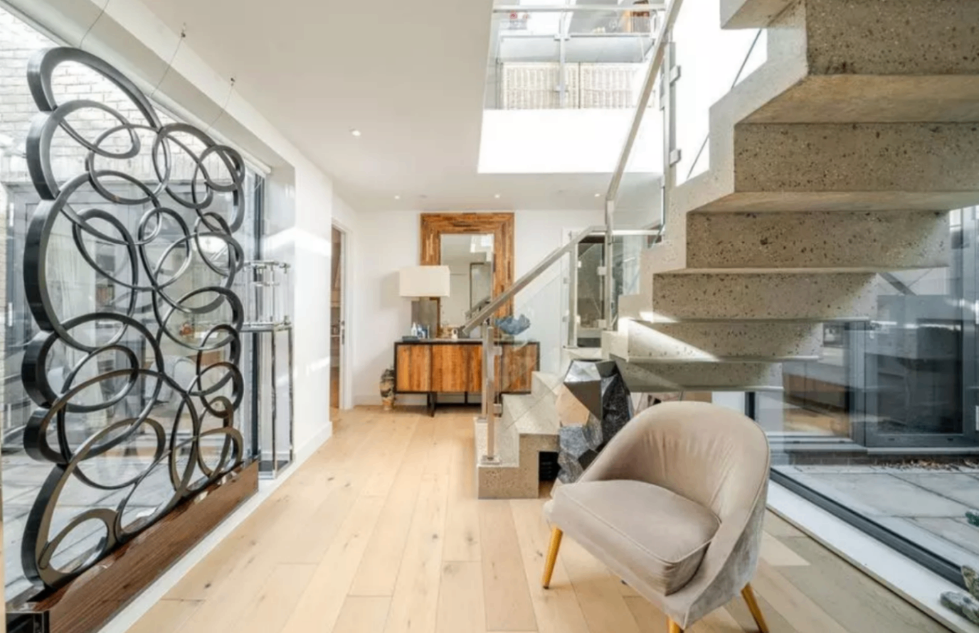 Luxury interior with floating concrete staircase, glass balustrade and bespoke metalwork screen